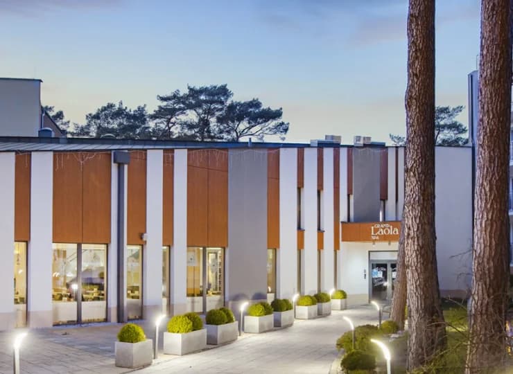Budynek hotelowy znajduje się pośród sosnowych drzew