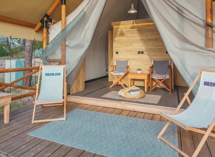 4-osobowy Forest Lodge M rozpoczyna się częścią z leżakami, w głębi 2 sypialnie