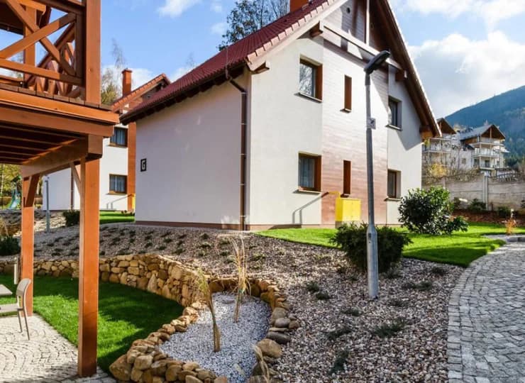 Domki oddzielone są alejkami i terenem zielonym
