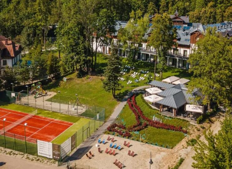 Na zewnątrz przygotowano plac zabaw, plażę przy promenadzie, korty tenisowe