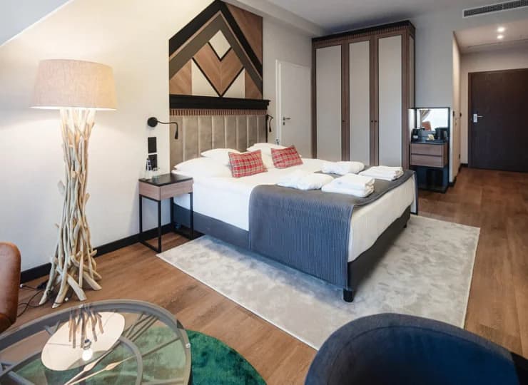 Pokój comfort ma designerskie dodatki, np. stylową lampę