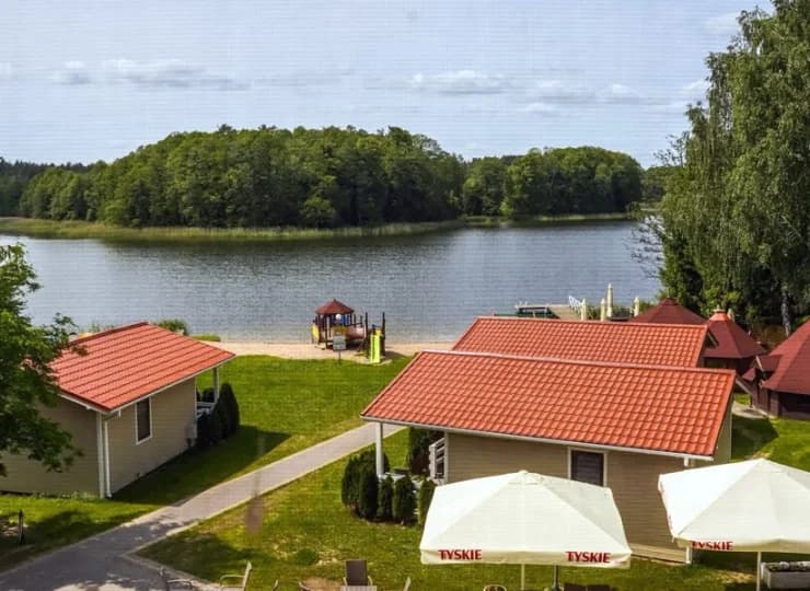 Ośrodek na Mazurach oferuje pokoje w pensjonacie oraz wolnostojące domki