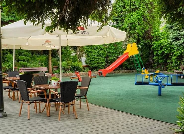 W ogrodzie jest plac zabaw dla dzieci i stoliki dla dorosłych