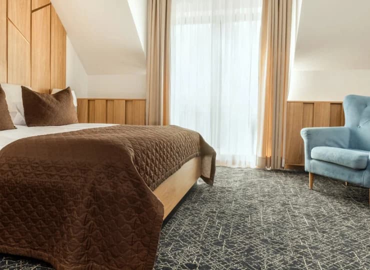 W pokojach Deluxe ustawiono duże małżeńskie łoża