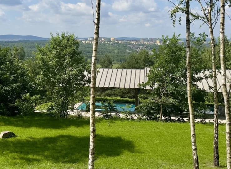 Hotelowy ogród z widocznymi onsenami i panoramą gór