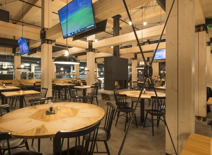 Restauracja jest wykończona w drewnie, posiada kominek i duże ekrany