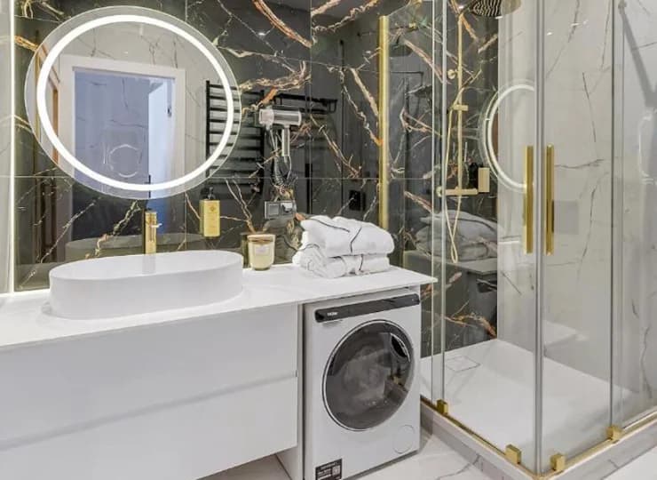 Łazienka z prysznicem i pralką w apartamencie 2+2 z sauną