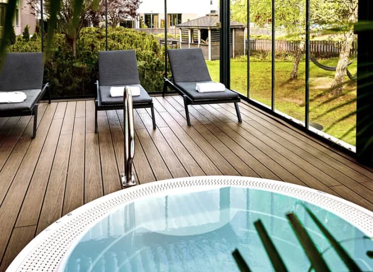 Wokół jacuzzi ustawiono leżaki, z których można podziwiać ogród