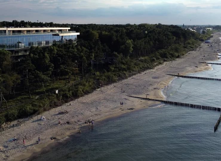 Obiekt wyłania się wprost z nadmorskiego lasu