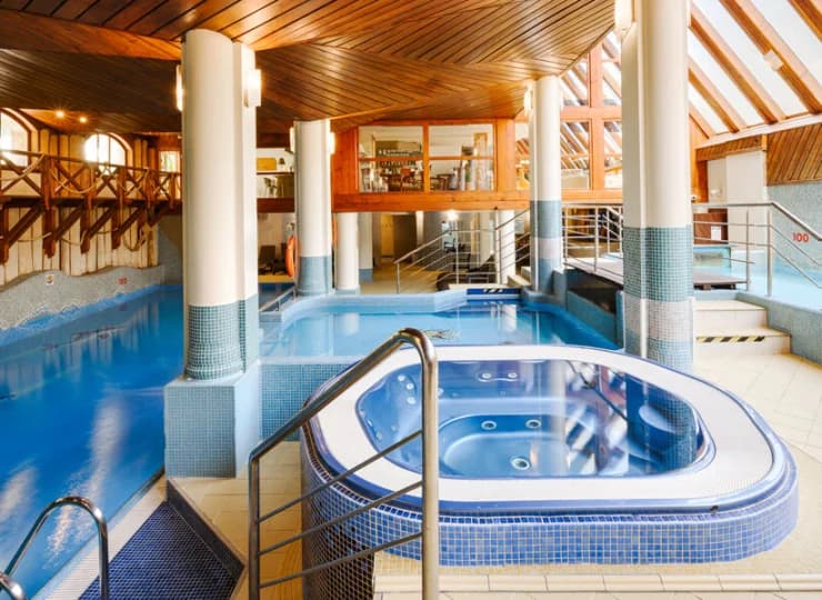 Obok basenu jest też jacuzzi i zjeżdżalnia wodna