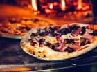 Pizza jest wypiekana w piecu opalanym drewnem