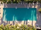 Hotel posiada sezonowy zewnętrzny basen z leżakami otoczony palmami