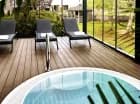 Wokół jacuzzi ustawiono leżaki, z których można podziwiać ogród