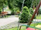 W zadbanym ogrodzie przygotowano plac zabaw ze zjeżdżalnią, huśtawką itp