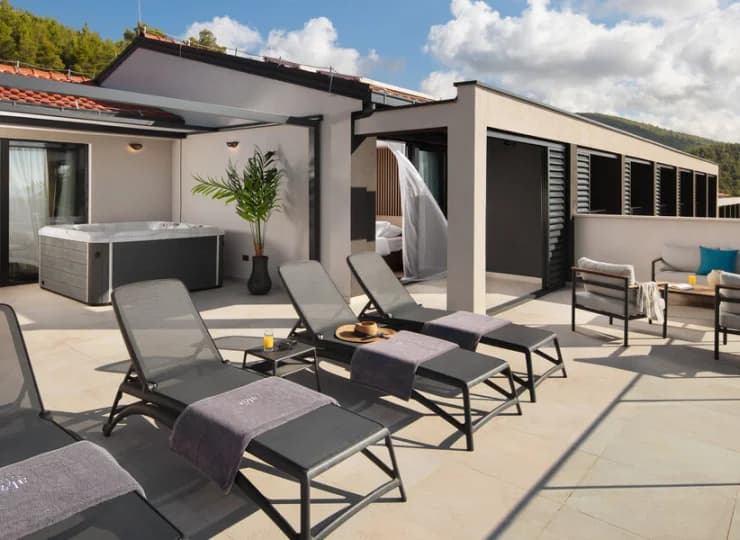 Na tarasie Luxury Suite jest jacuzzi, leżaki, stolik z fotelami