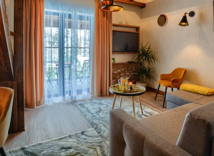 Apartament składa się z pokoju dziennego z sofą, TV i miejscem do pracy