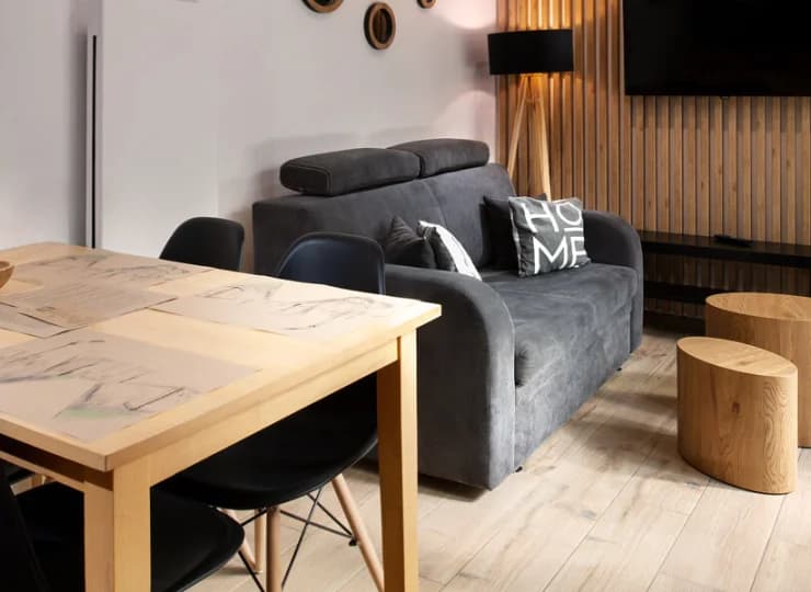 Domek posiada funkcjonalny salon z sofą i aneksem kuchennym