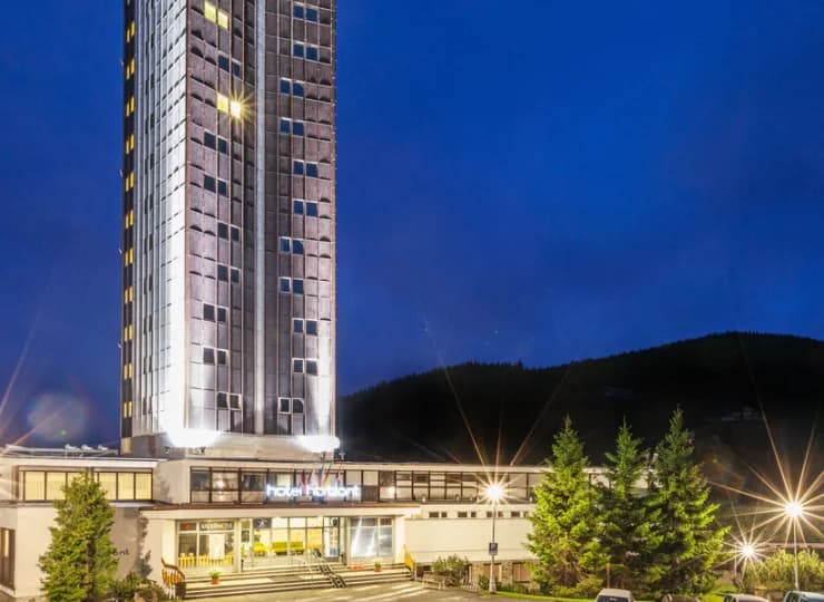 Hotel ma kształt wysokiej wieży, dzięki czemu pokoje oferują widoki na góry