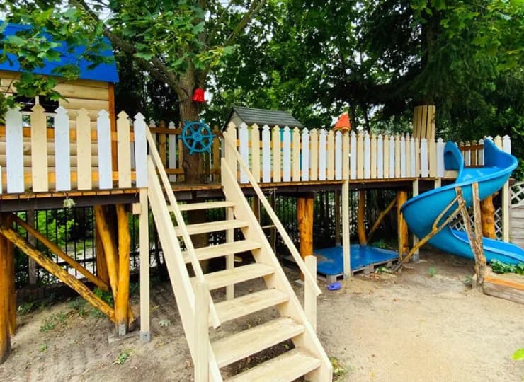 Na małych gości czeka także pomysłowy plac zabaw z domkiem na drzewie