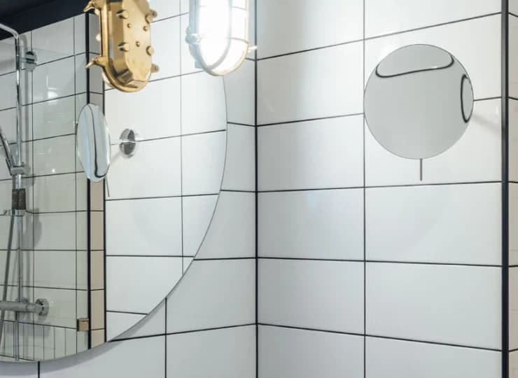 Łazienka z kabiną prysznicową, kosmetykami, suszarką do włosów, ręcznikami