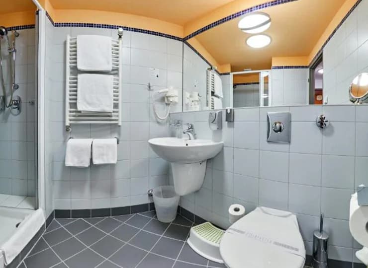 W łazience jest prysznic, suszarka do włosów, ręczniki