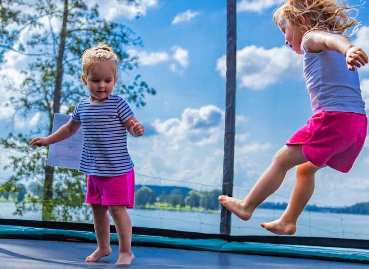 Na zewnątrz czeka na dzieci trampolina skryta w cieniu drzew