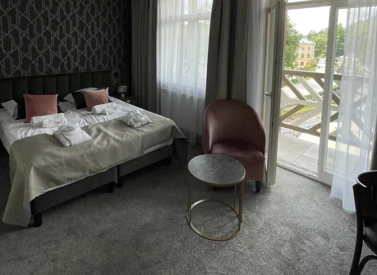 Oraz wygodnej sypialni z wyjściem na balkon z widokiem na uzdrowisko