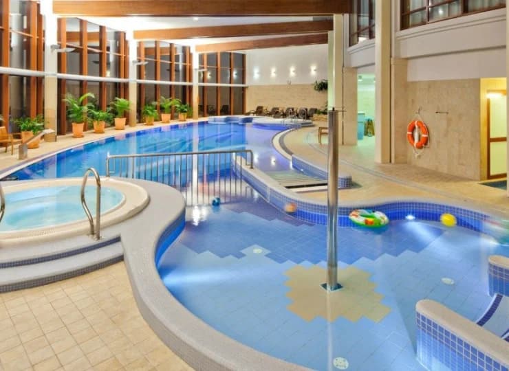 W basenie wydzielono płytki brodzik dla dzieci, obok znalazło się jacuzzi