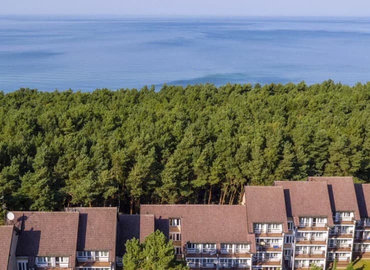 Od szerokiej piaszczystej plaży oddziela go tylko pas sosnowego lasu