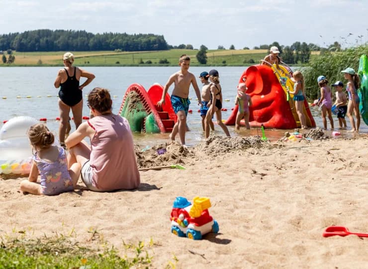 Na plaży są leżaki, małe zjeżdżalnie i sprzęt wodny