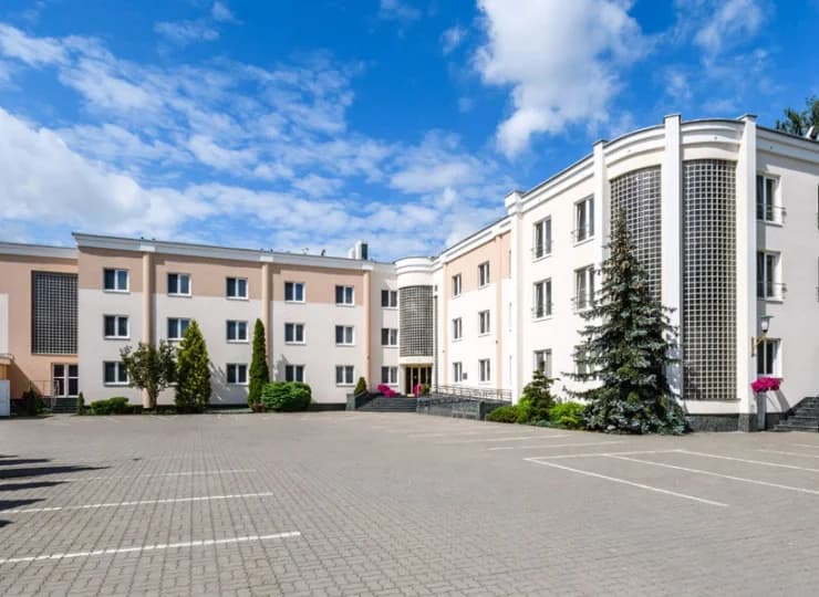 To niski obiekt na dużym terenie z ogrodem ładnie wkomponowany w otoczenie