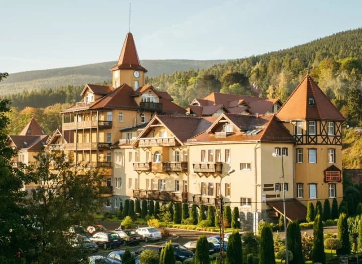 Budynek jest otoczony górskimi panoramami