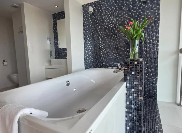 Apartament posiada otwartą łazienkę z wanną z hydromasażem tuż przy łóżku