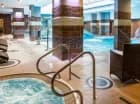 Obok basenu są leżaki i jacuzzi