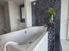 Apartament posiada otwartą łazienkę z wanną z hydromasażem tuż przy łóżku