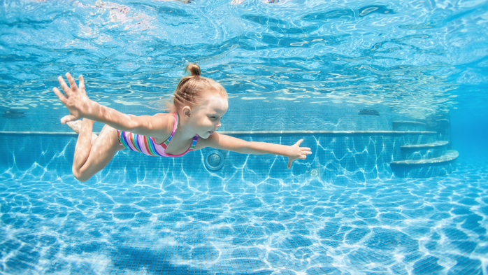 Dziewczynka pływająca w basenie hotelowym