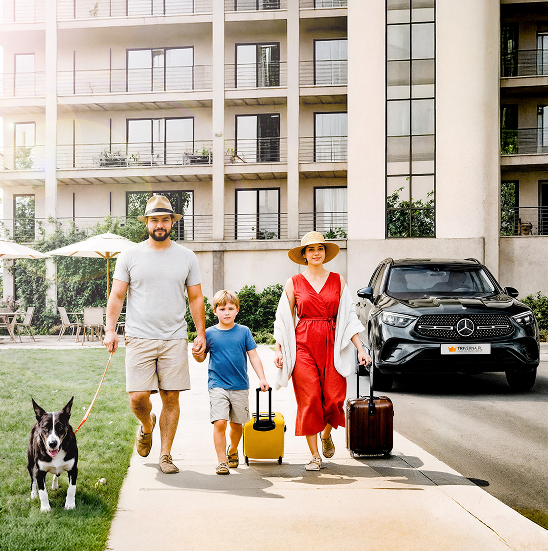 Family with luxury hotel and Mercedes car